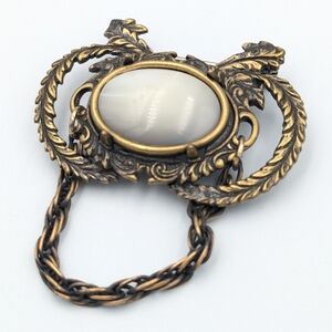 Vintaged darkened brass tone brooch pin with chain and white cabochon